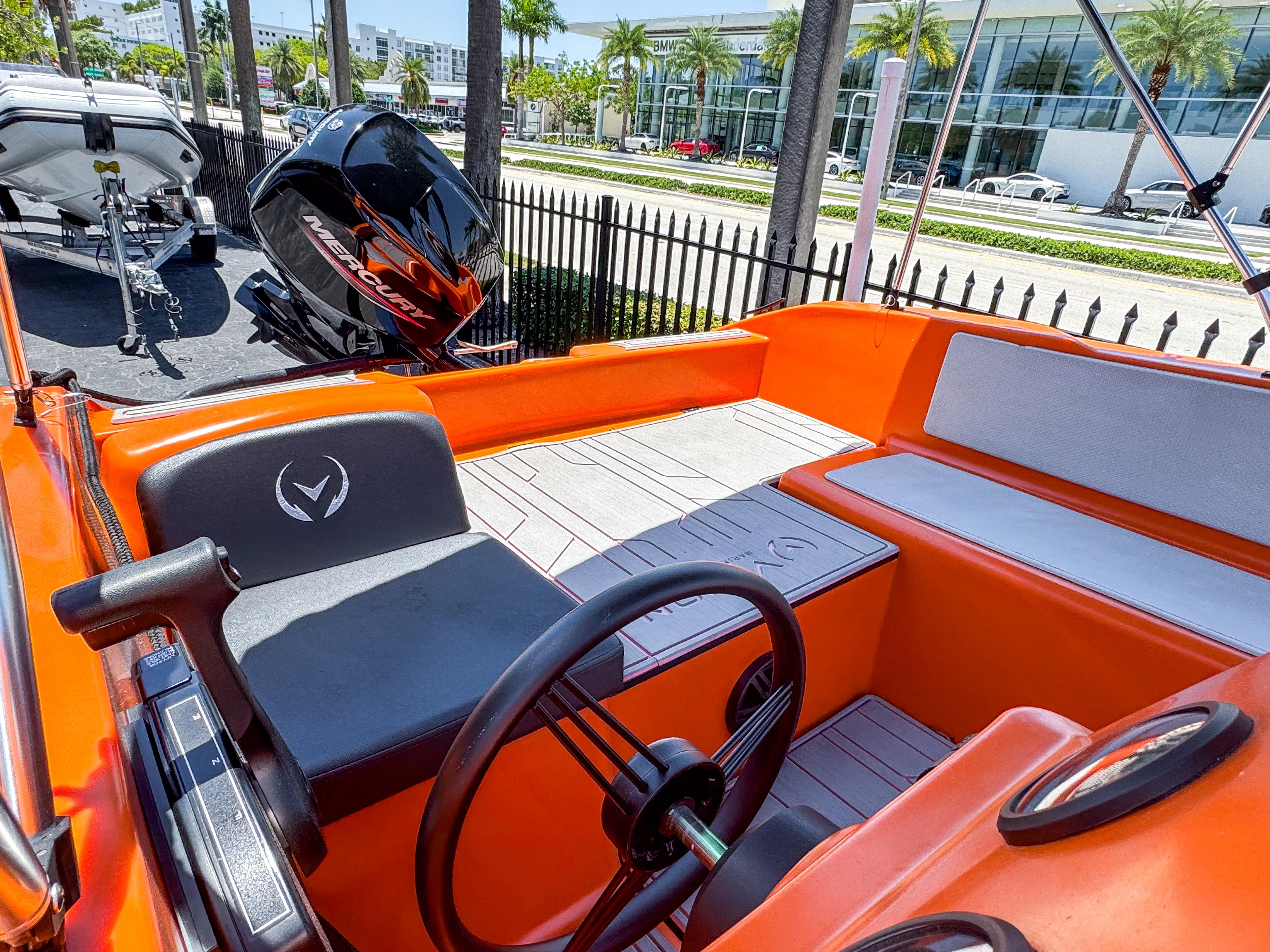 2024 Vision Marine Technologies Phantom boat interior with orange seating and steering wheel.