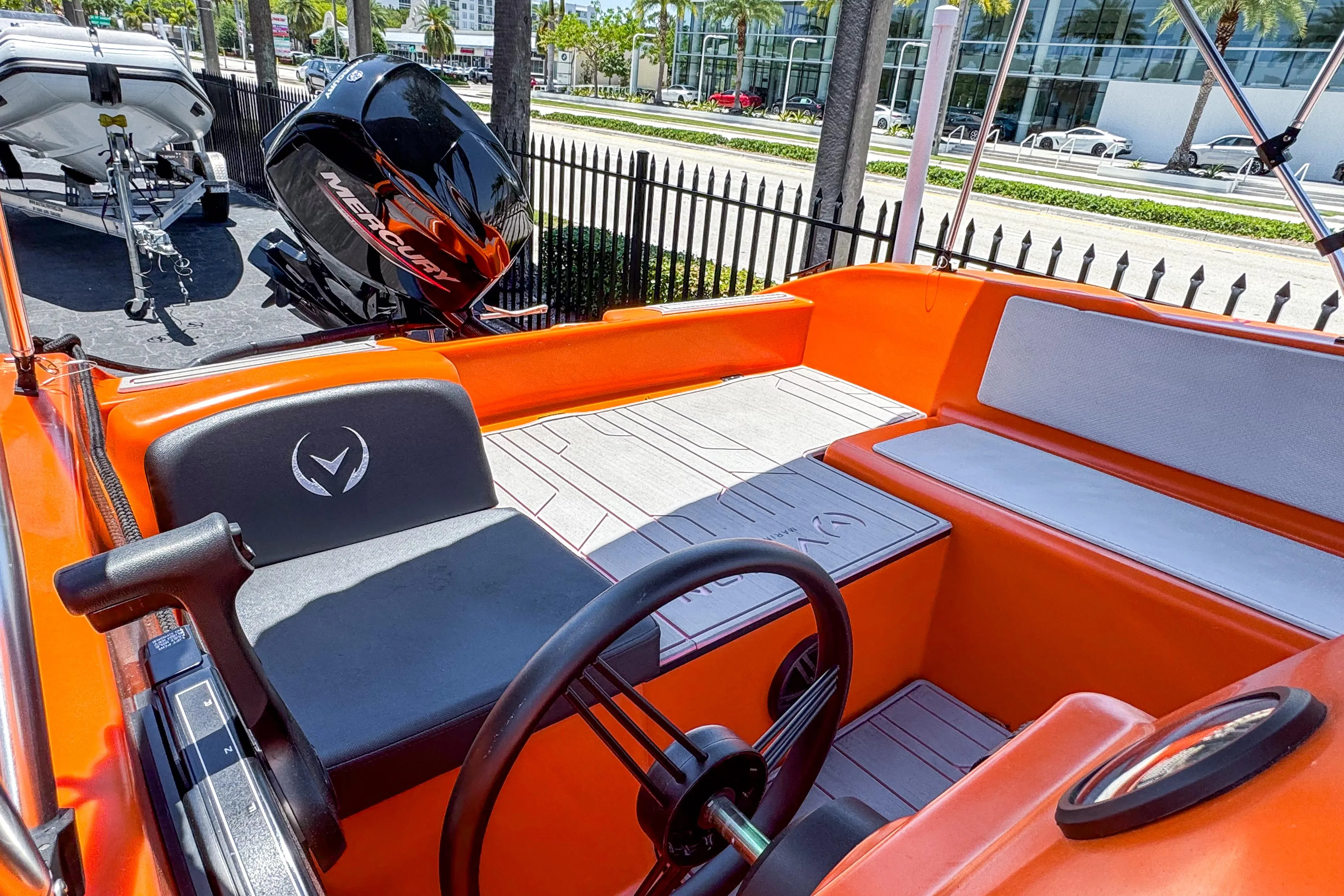 2024 Vision Marine Technologies Phantom boat interior with orange seating and steering wheel.