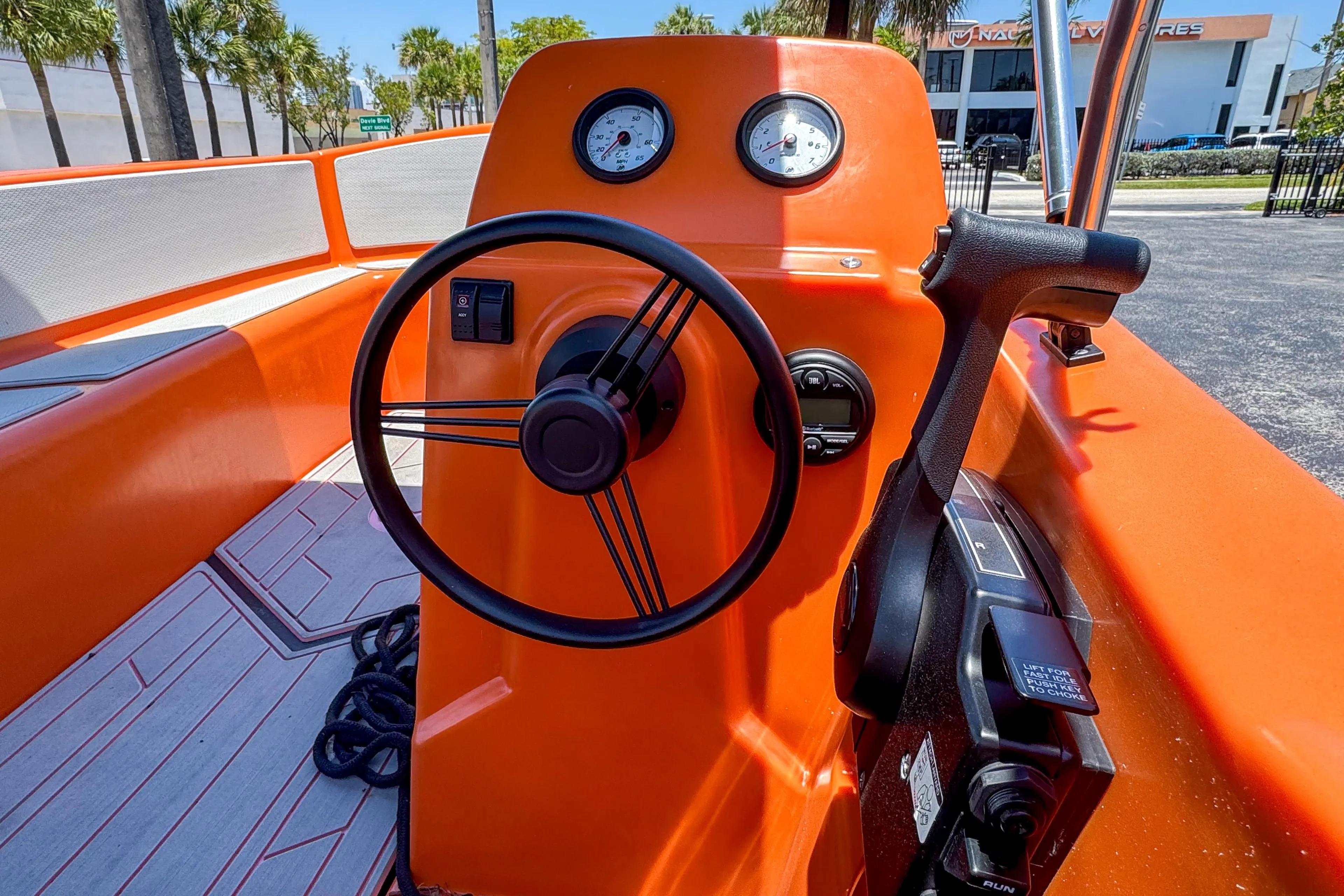 2024 Vision Marine Technologies Phantom boat cockpit with orange dashboard and steering wheel.