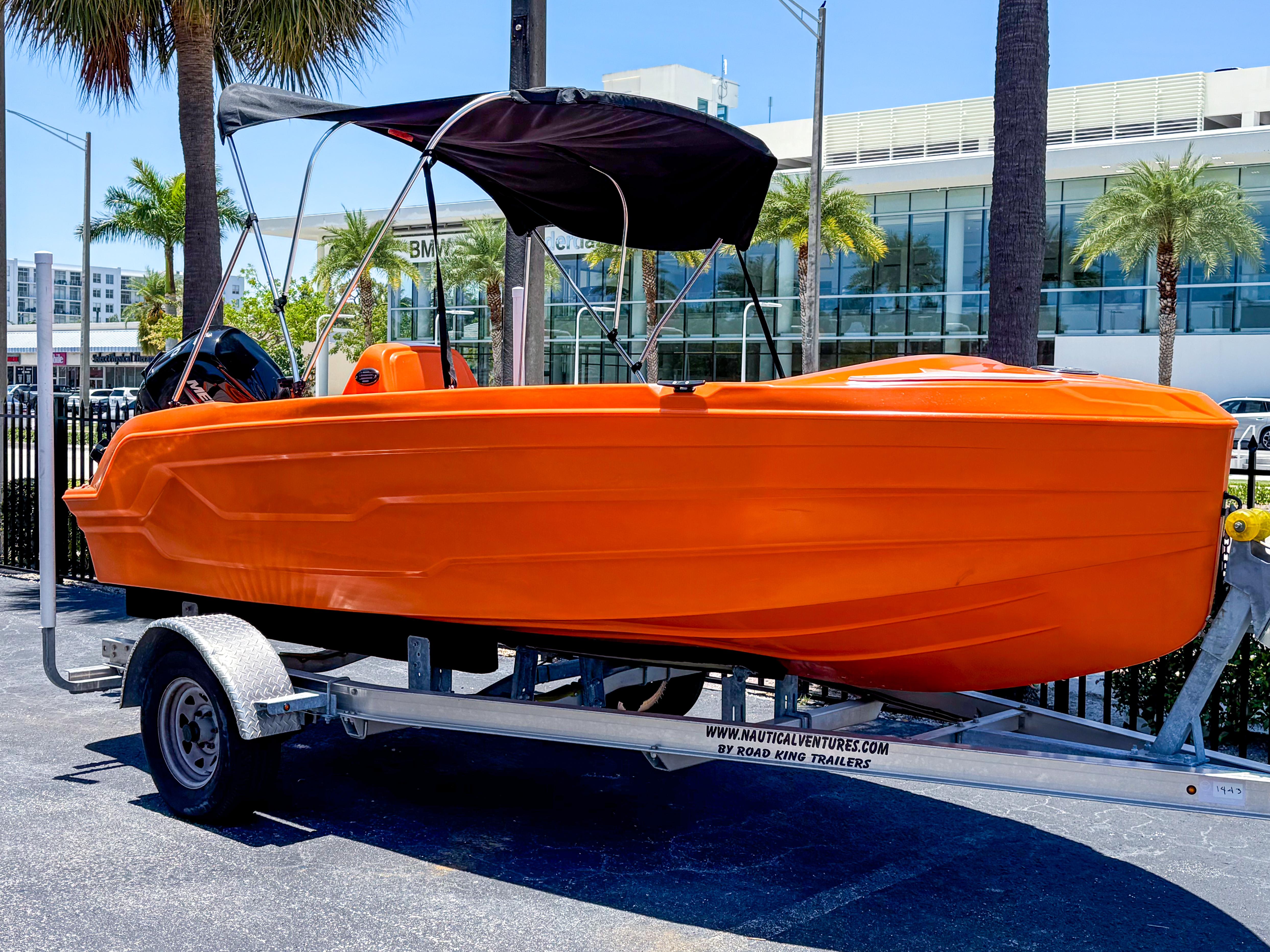 2024 Vision Marine Technologies Phantom boat in vibrant orange on a trailer.