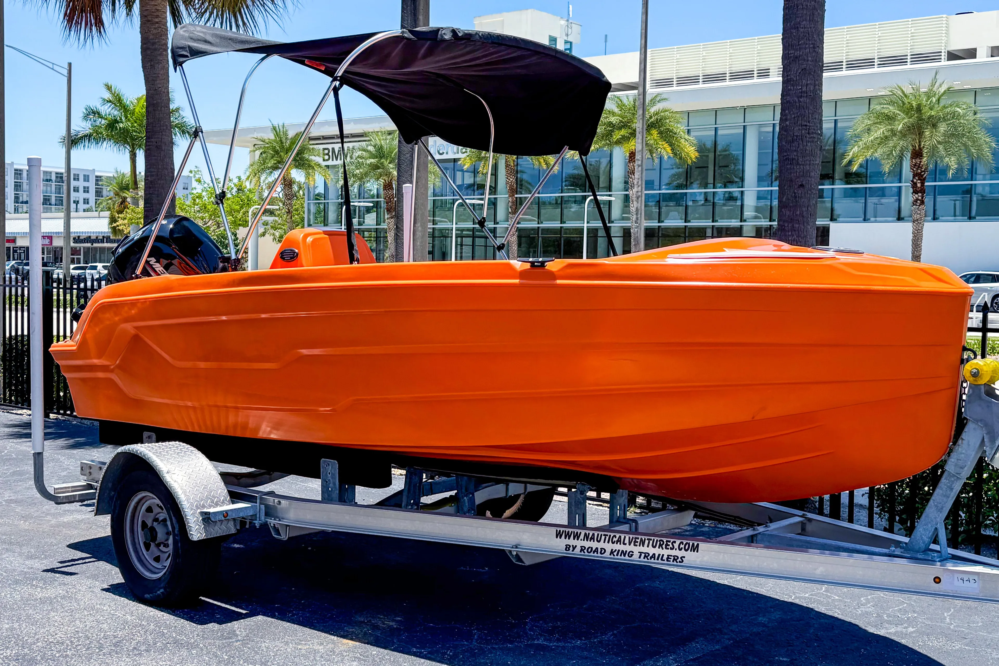 2024 Vision Marine Technologies Phantom boat in vibrant orange on a trailer.