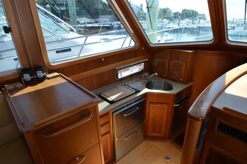 Sea Pilot Yacht Photos Pics 2014 Sabre 42 Salon Express interior with compact kitchen and wooden cabinetry.