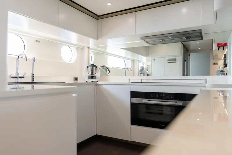 Palmax Yacht Photos Pics Modern kitchen interior on 2022 Azimut Magellano 30M yacht, featuring sleek white cabinetry and appliances.