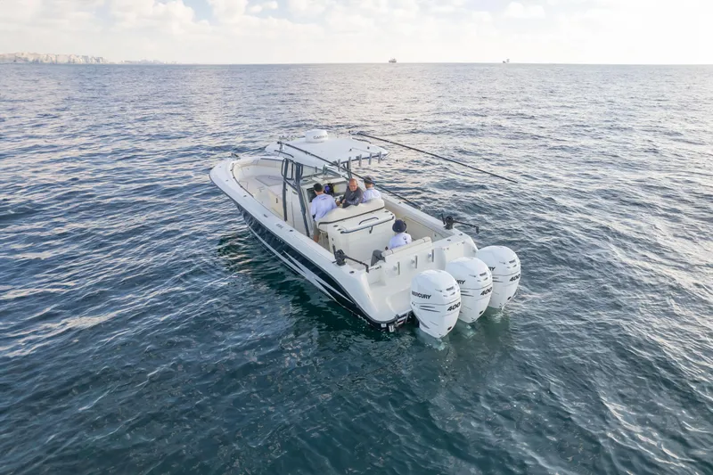  Yacht Photos Pics 2022 Hydra-Sports 3400 boat cruising on open water with triple outboard engines.