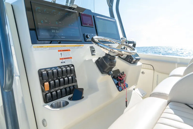 Yacht Photos Pics 2022 Hydra-Sports 3400 boat dashboard with steering wheel and electronic controls.