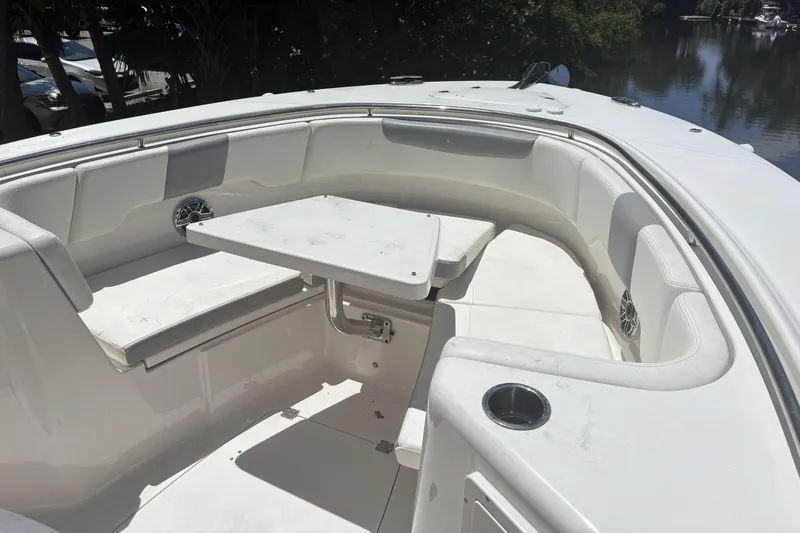 302-112 Yacht Photos Pics 2023 Robalo R302 Center Console boat with white seating and table in the bow area.