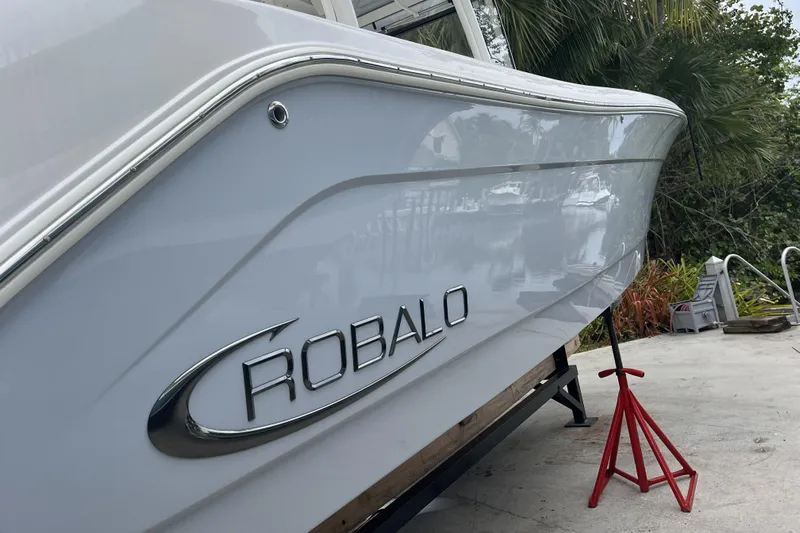 302-112 Yacht Photos Pics 2023 Robalo R302 Center Console boat on stands, side view with logo.