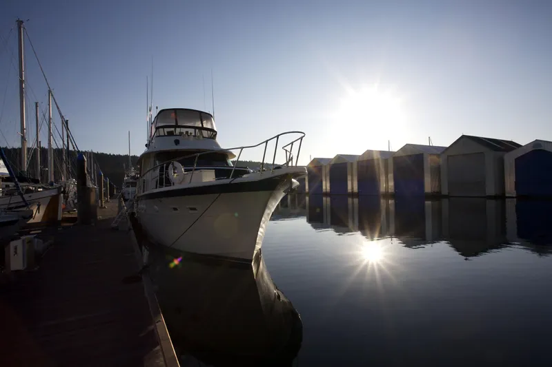  Yacht Photos Pics Custom OBMG Boathouse 2025 yacht docked at marina during sunrise, reflecting on calm water.