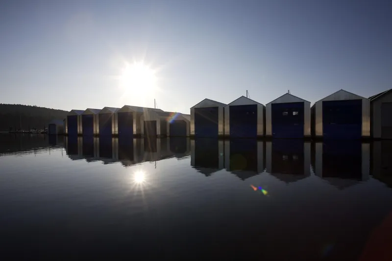 Yacht Photos Pics Boathouses reflecting on water at sunset, Custom OBMG Boathouse, 2025 model.