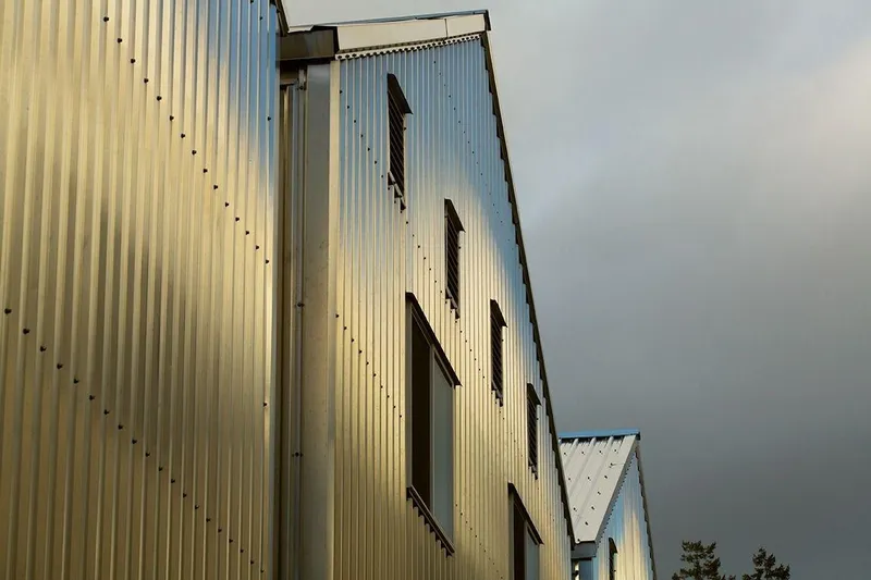  Yacht Photos Pics Modern metal-clad boathouse exterior under cloudy sky, Custom OBMG model, 2025 design.