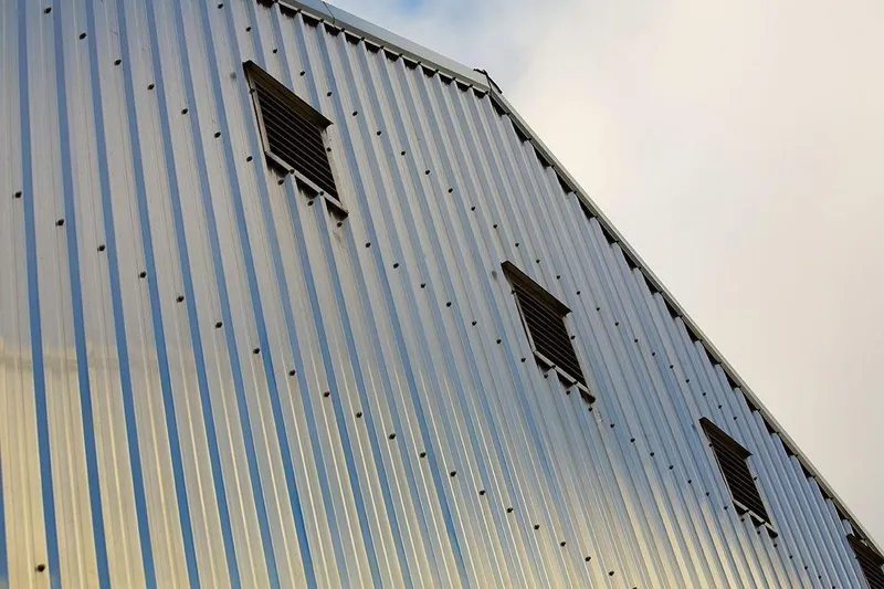  Yacht Photos Pics Metallic exterior of 2025 Custom OBMG Boathouse with vents against cloudy sky.