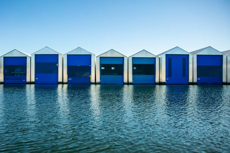  Yacht Photos Pics Row of blue boathouses on water, Custom OBMG Boathouse model, 2025.