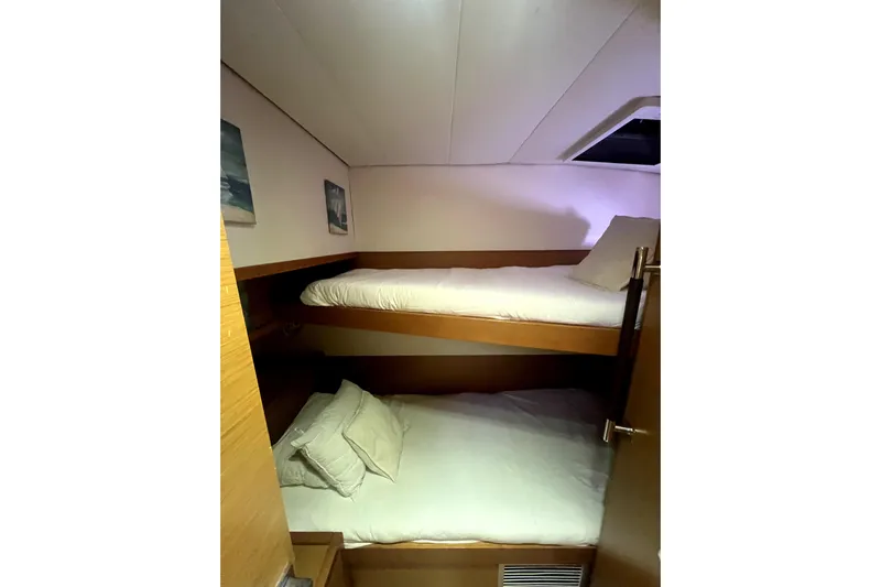 Capricho Yacht Photos Pics Bunk beds in 2011 Lagoon 560 yacht cabin, featuring cozy bedding and wooden interior.