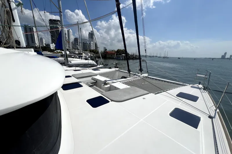 Capricho Yacht Photos Pics Lagoon 560 catamaran from 2011 docked in a marina with city skyline.