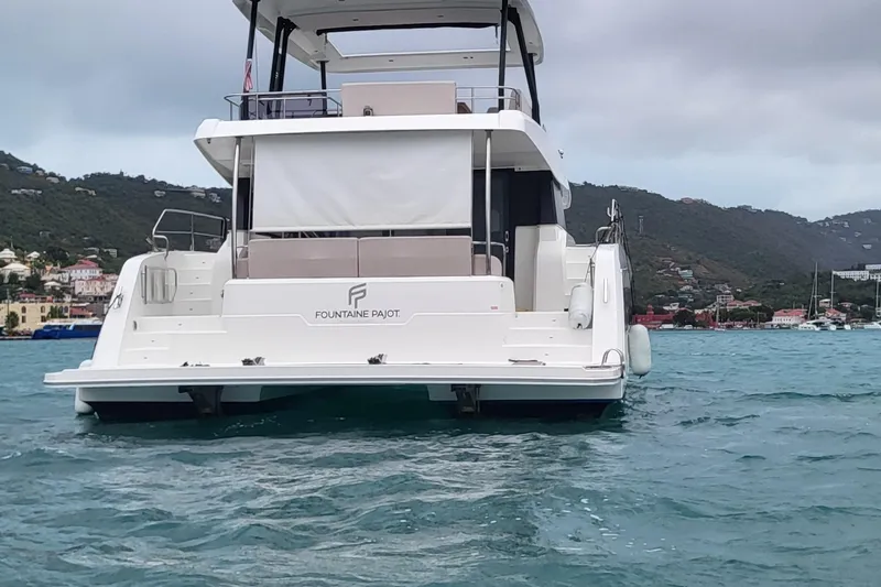  Yacht Photos Pics 2024 Fountaine Pajot MY6 yacht on water, scenic coastal backdrop.