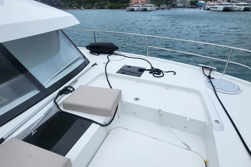  Yacht Photos Pics 2024 Fountaine Pajot MY6 yacht deck with seating, moored by the water.