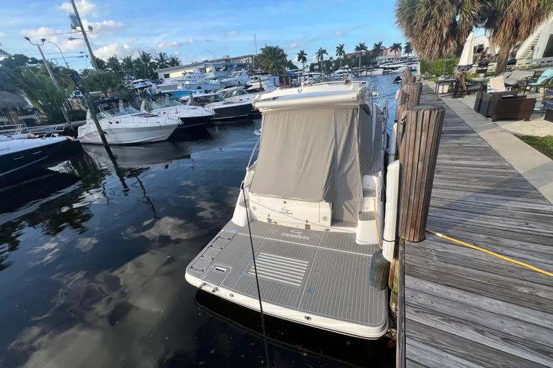 Romaniac Yacht Photos Pics Evolve 400HT 2021 yacht docked at marina with surrounding boats and palm trees.
