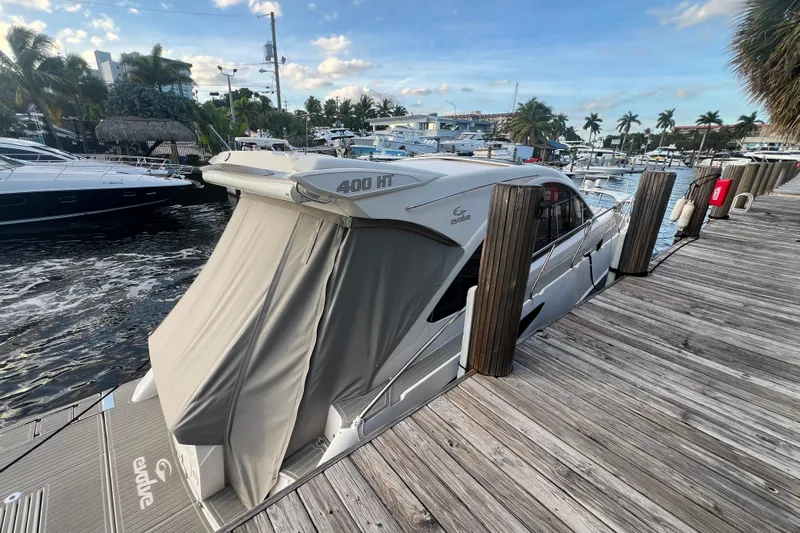 Romaniac Yacht Photos Pics 2021 Evolve 400HT yacht docked at marina with scenic waterfront view.