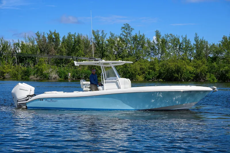  Yacht Photos Pics 2023 Powerplay Powerboats 30 RumRunner on a serene lake with lush greenery.