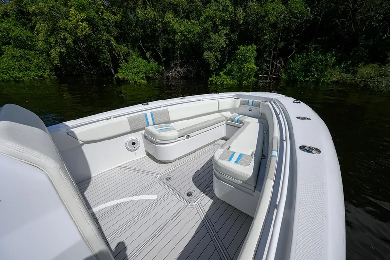  Yacht Photos Pics 2023 Powerplay Powerboats 30 RumRunner with sleek seating, docked by lush greenery.