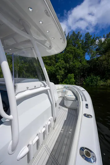  Yacht Photos Pics 2023 Powerplay Powerboats 30 RumRunner on a serene river, surrounded by lush greenery.