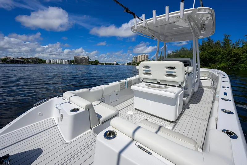  Yacht Photos Pics 2023 Powerplay Powerboats 30 RumRunner on scenic waterway, featuring sleek white deck design.