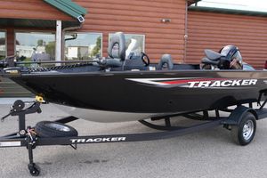 2026 Tracker Pro Guide V-175 WT boat on trailer, parked outside a wooden building.