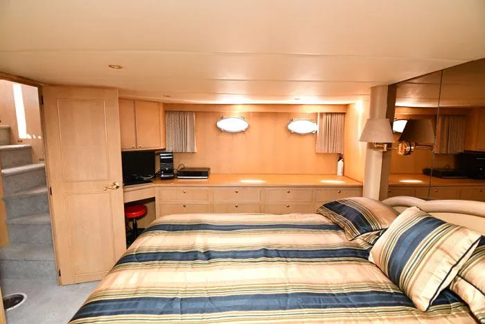  Yacht Photos Pics Luxurious bedroom interior of 1997 Forbes Cooper 74 Pilothouse yacht with striped bedding.