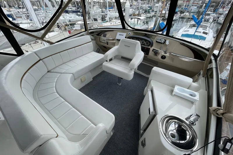 Minnow Yacht Photos Pics 2006 Carver 39 Motor Yacht interior with white seating, helm, and marina view.
