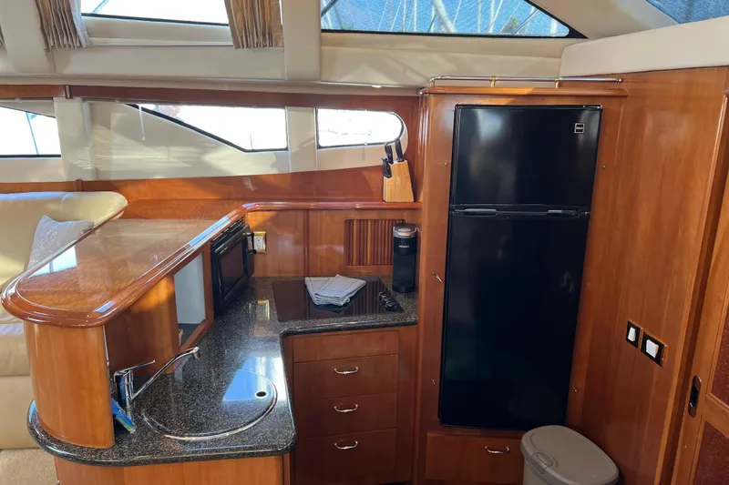 Minnow Yacht Photos Pics Luxurious kitchen interior of 2006 Carver 39 Motor Yacht with wood cabinetry and modern appliances.