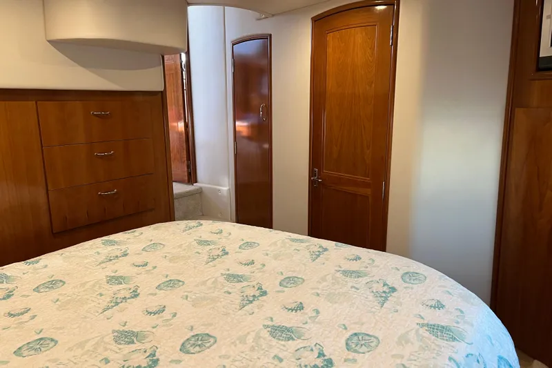 Minnow Yacht Photos Pics Interior of 2006 Carver 39 Motor Yacht bedroom with wooden cabinets and patterned bedding.