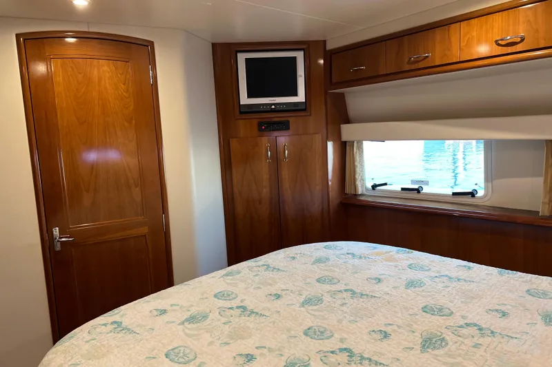 Minnow Yacht Photos Pics 2006 Carver 39 Motor Yacht bedroom with wood cabinetry, TV, and window view.