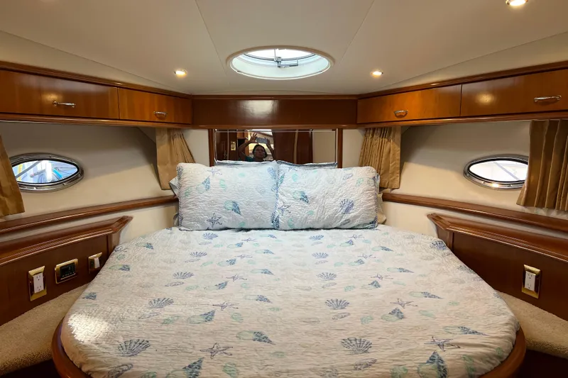 Minnow Yacht Photos Pics Luxurious 2006 Carver 39 Motor Yacht bedroom with elegant wood cabinetry and cozy bedding.