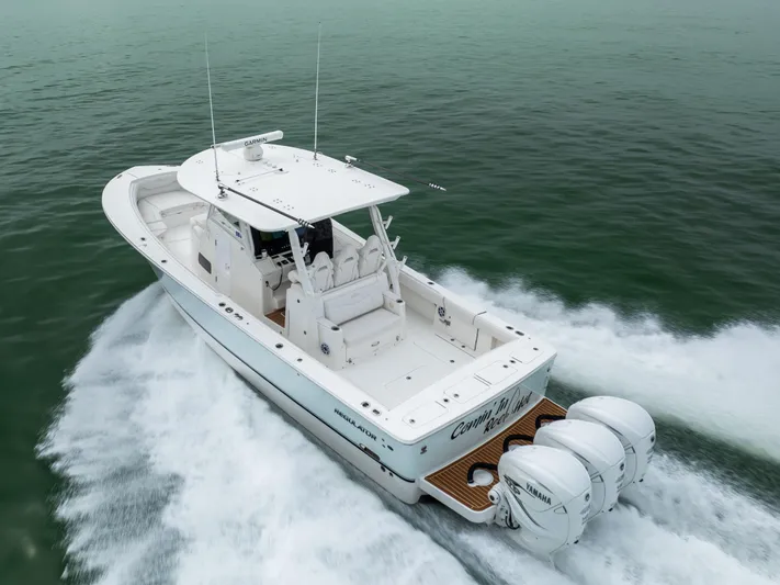 Comin In Reel Hot Yacht Photos Pics 2023 Regulator 37 boat cruising on open water, featuring triple outboard engines.