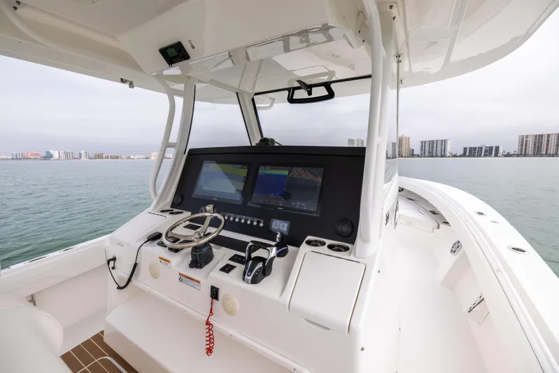 Comin In Reel Hot Yacht Photos Pics 2023 Regulator 37 boat helm with dual screens on calm water.