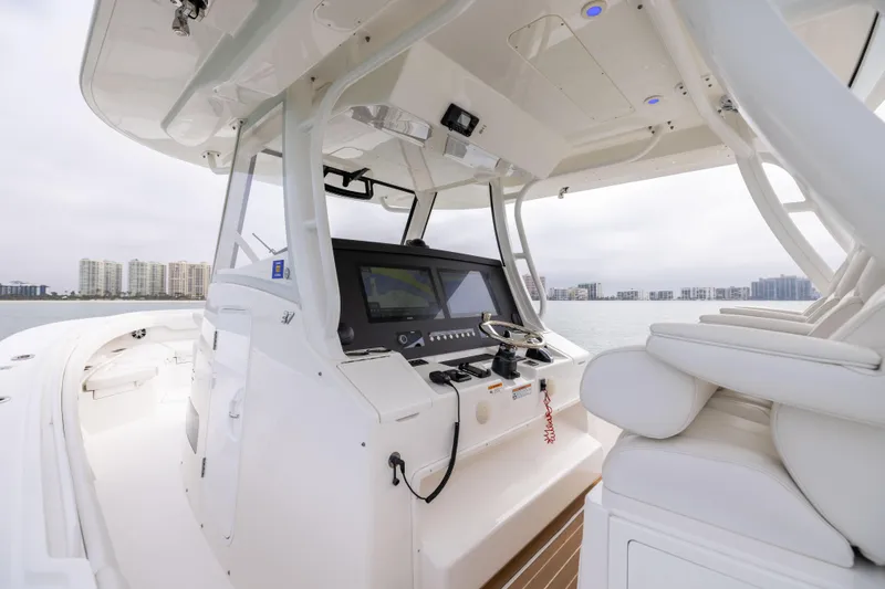 Comin In Reel Hot Yacht Photos Pics 2023 Regulator 37 boat interior with modern helm and seating, overlooking waterfront skyline.