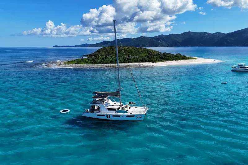 Tapas Yacht Photos Pics Royal Cape Catamarans 570 Flybridge 2023 sailing near tropical island with clear blue waters.