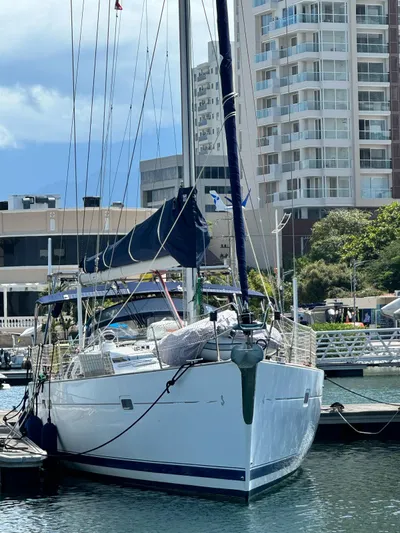  Yacht Photos Pics 2006 Beneteau Oceanis 473 sailboat docked in a marina with cityscape background.