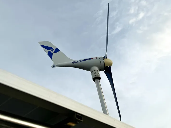  Yacht Photos Pics Wind turbine on a 2006 Beneteau Oceanis 473 sailboat against a cloudy sky.