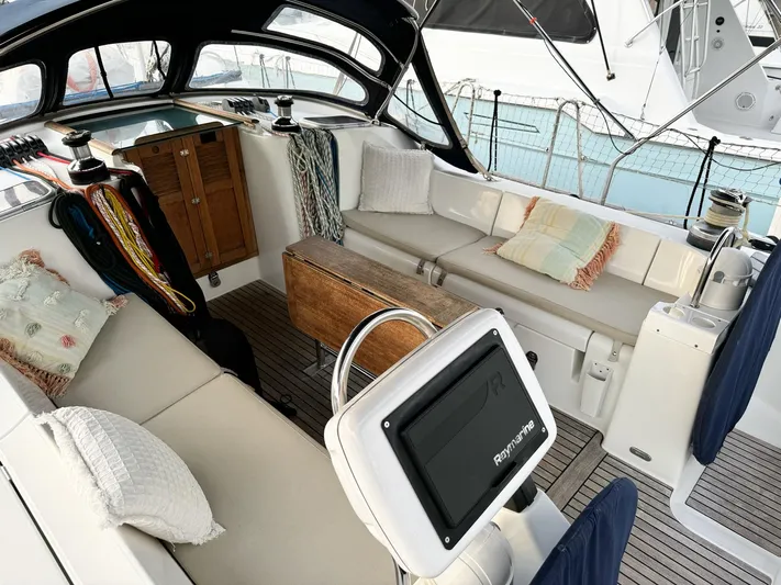  Yacht Photos Pics 2006 Beneteau Oceanis 473 yacht cockpit with seating, cushions, and navigation equipment.