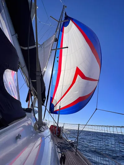  Yacht Photos Pics Sailing on a 2006 Beneteau Oceanis 473 with colorful spinnaker against clear blue sky.