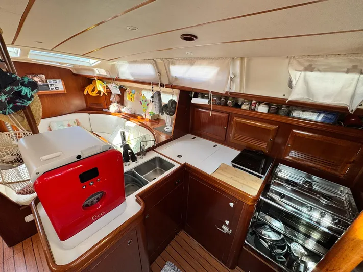  Yacht Photos Pics Interior of 2006 Beneteau Oceanis 473 yacht kitchen with modern appliances and wooden cabinetry.