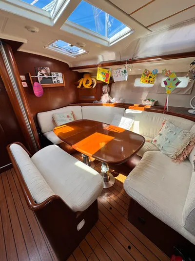  Yacht Photos Pics Interior of 2006 Beneteau Oceanis 473 sailboat with cozy seating and decorative artwork.