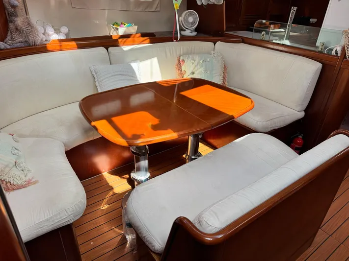  Yacht Photos Pics Interior of 2006 Beneteau Oceanis 473 yacht with cozy seating and wooden table.