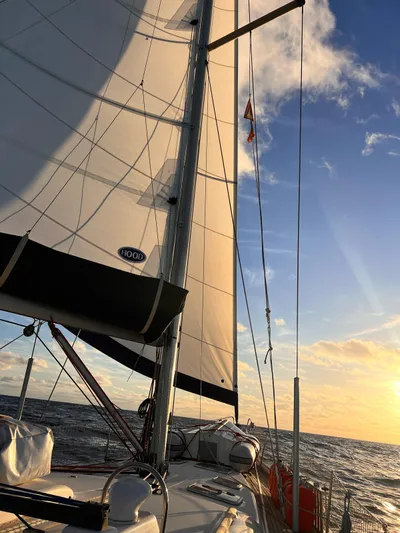  Yacht Photos Pics Sailing on a 2006 Beneteau Oceanis 473 at sunset, open sea view.