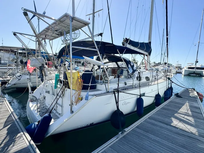  Yacht Photos Pics 2006 Beneteau Oceanis 473 sailboat docked at marina, featuring blue canopy and solar panels.