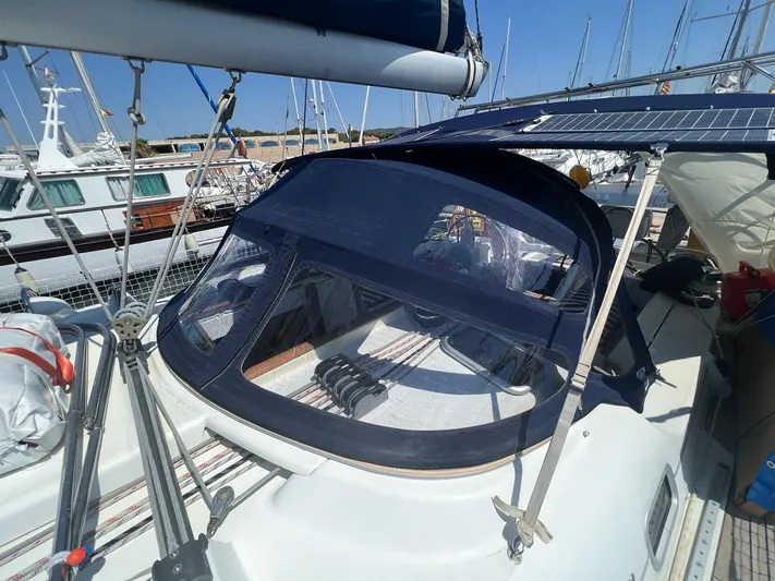  Yacht Photos Pics Beneteau Oceanis 473 sailboat, 2006 model, with blue canopy and solar panels, docked at marina.