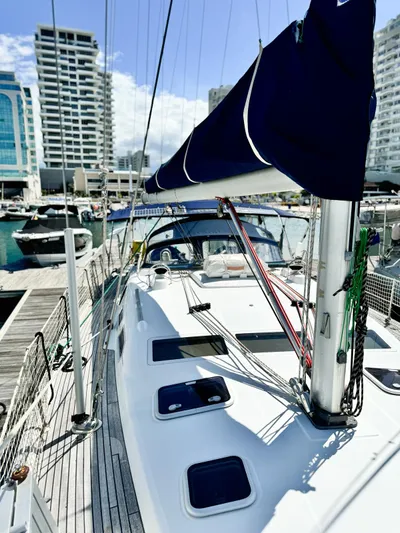  Yacht Photos Pics 2006 Beneteau Oceanis 473 sailboat docked at a marina with cityscape background.