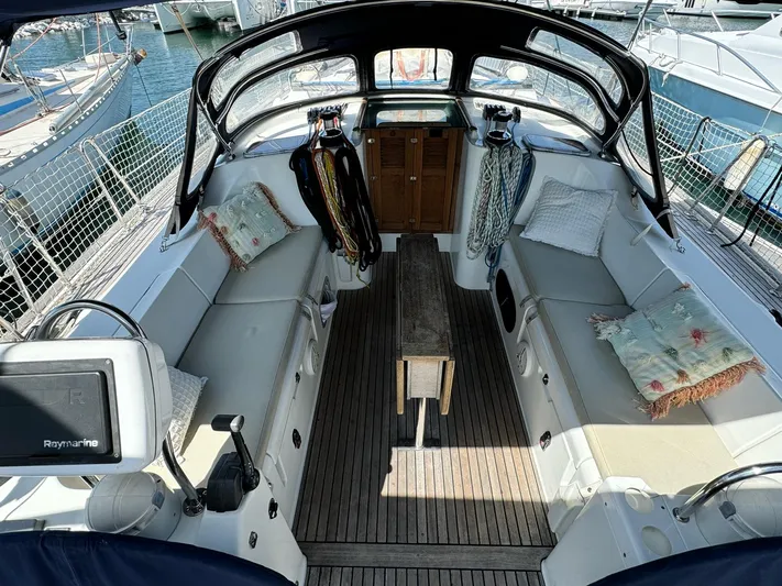  Yacht Photos Pics 2006 Beneteau Oceanis 473 sailboat cockpit with seating, wooden table, and nautical equipment.