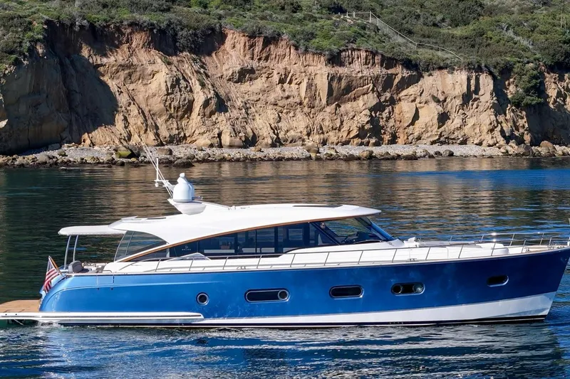 Valencia Yacht Photos Pics 2019 Belize 66 Sedan yacht cruising near rocky coastline.